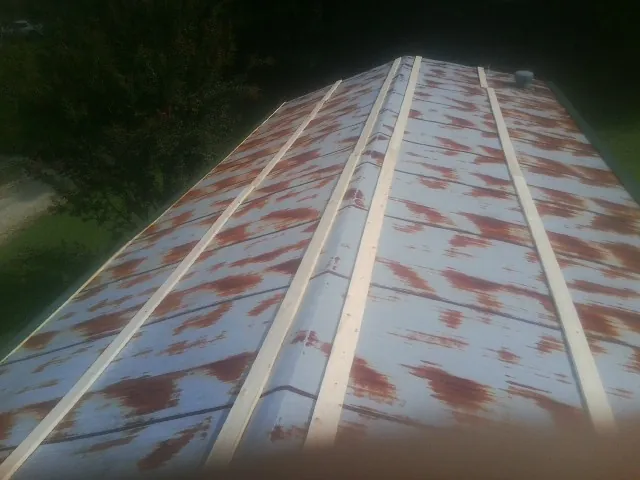 Rusted metal roof panels with new wood purlins before replacement — Storm Damage Roof Repair in Basile by Roofing Brothers