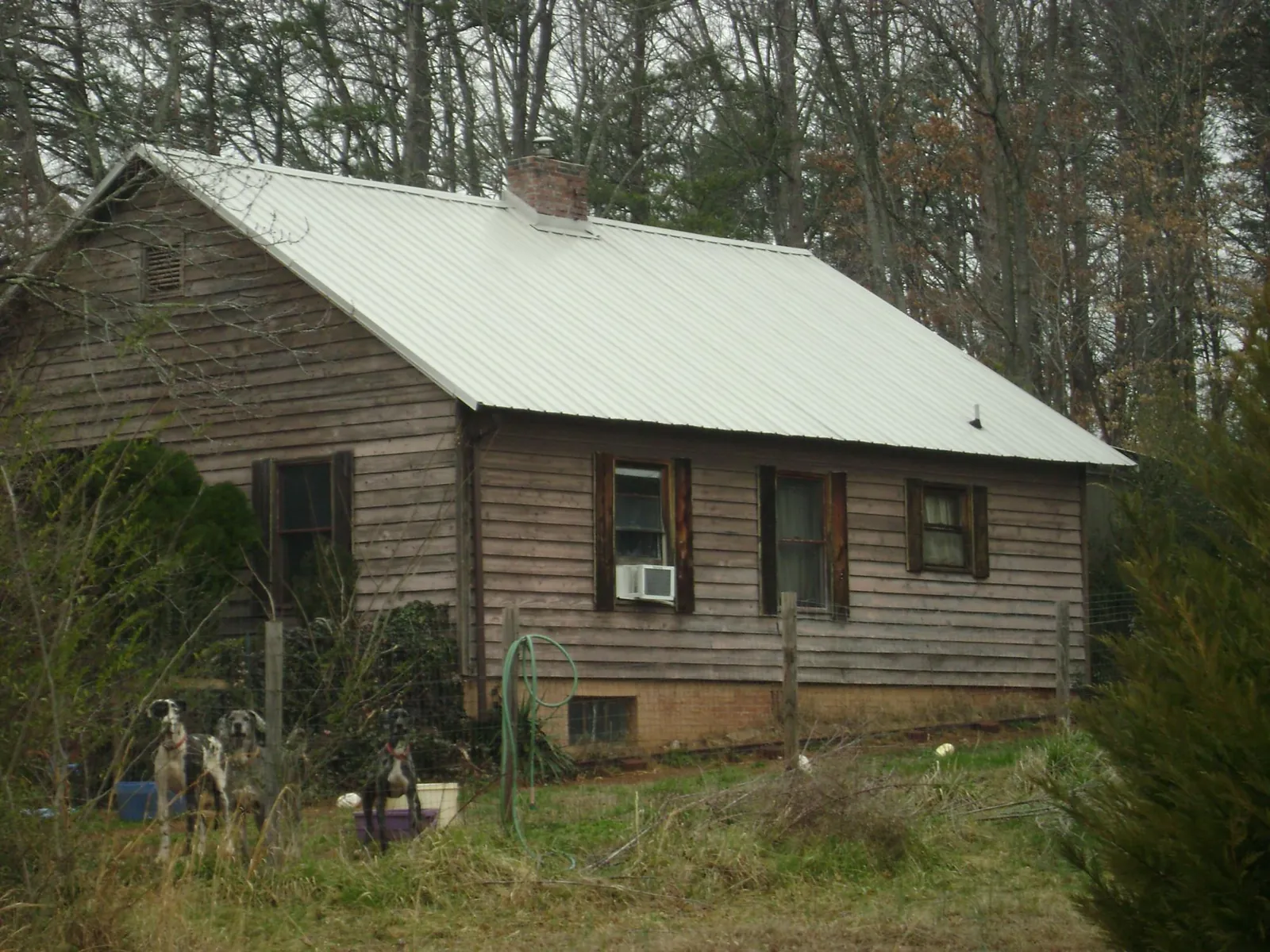 White metal roof on an old wood sided farmhouse, from a Metal Roof Installation job in Basile